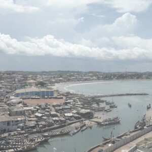 Elmina Castle Port Boats Fishing Shoreline Community Clouds Skies