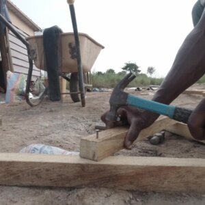 Carpenter Nails Into Wood On Site