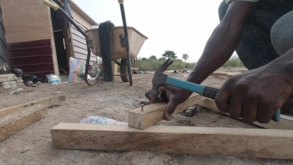 Carpenter Nails Into Wood On Site