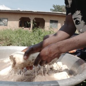 Man Washing Cassava In Water Pan Cleaning