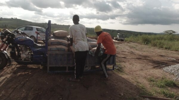 Men Offloading Cement Bags Construction