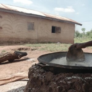 Woman Stir Gari In Pan On Fire